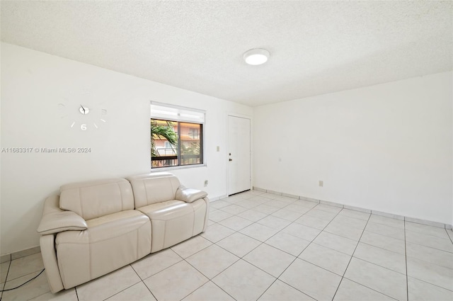 tiled living room featuring a textured ceiling