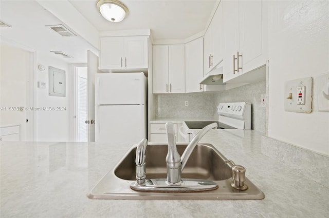 kitchen with white appliances, electric panel, sink, and white cabinets