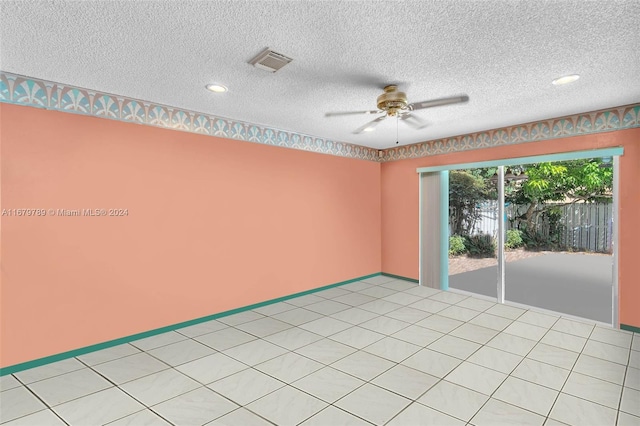 tiled empty room featuring a textured ceiling and ceiling fan