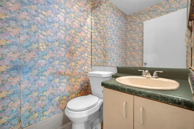 bathroom featuring vanity, a textured ceiling, and toilet