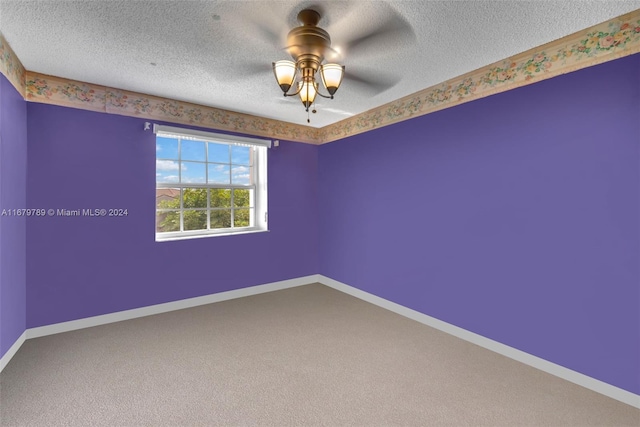 empty room with a textured ceiling, carpet floors, and ceiling fan