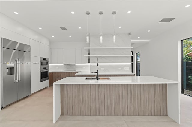 kitchen with visible vents, modern cabinets, appliances with stainless steel finishes, open shelves, and a sink