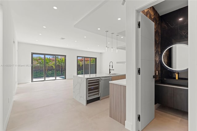 kitchen with kitchen peninsula, wine cooler, sink, pendant lighting, and stainless steel dishwasher