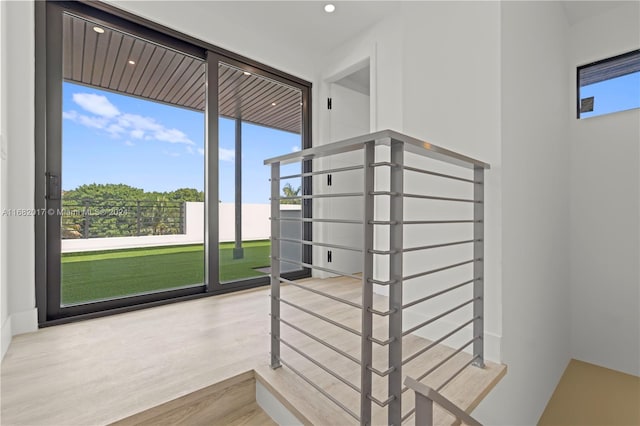 stairway featuring a wealth of natural light and hardwood / wood-style floors