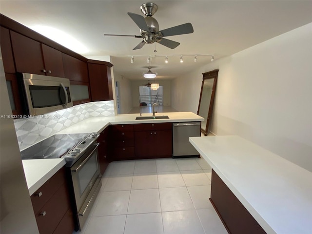 kitchen featuring tasteful backsplash, appliances with stainless steel finishes, sink, kitchen peninsula, and ceiling fan