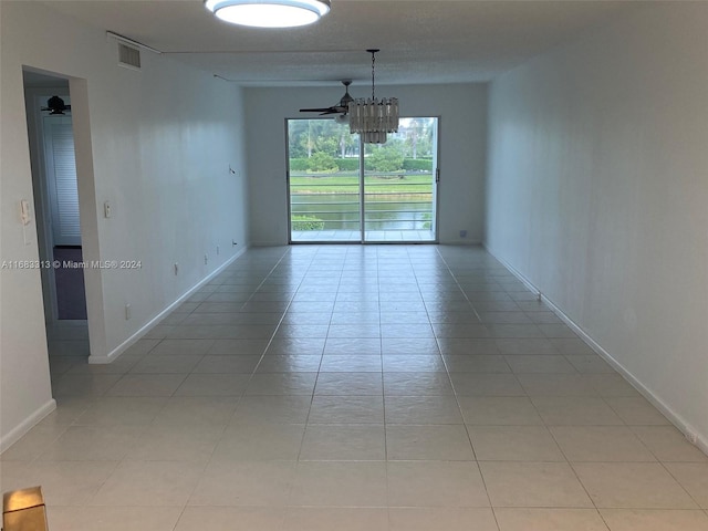 tiled empty room featuring ceiling fan