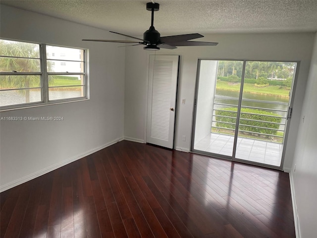 unfurnished bedroom featuring multiple windows, ceiling fan, and dark hardwood / wood-style floors