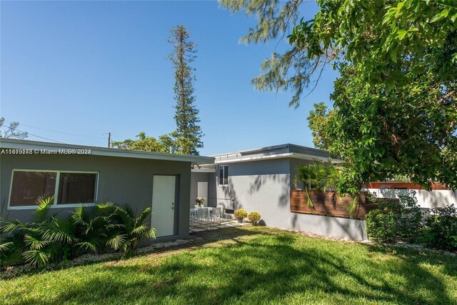11515 NE 12th Ave, Miami, FL 33161 - rear view of house with a lawn and stucco siding
