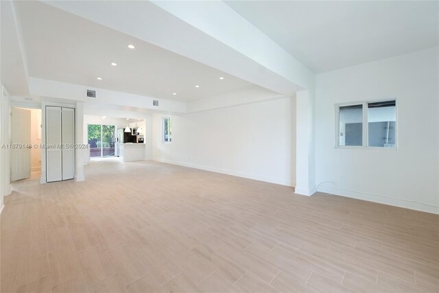 11515 NE 12th Ave, Miami, FL 33161 - unfurnished living room with light wood-style floors, recessed lighting, and a tray ceiling