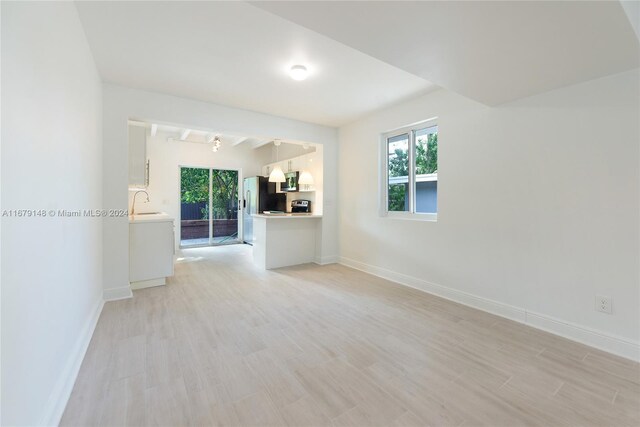 11515 NE 12th Ave, Miami, FL 33161 - unfurnished living room with healthy amount of natural light and light wood-style floors