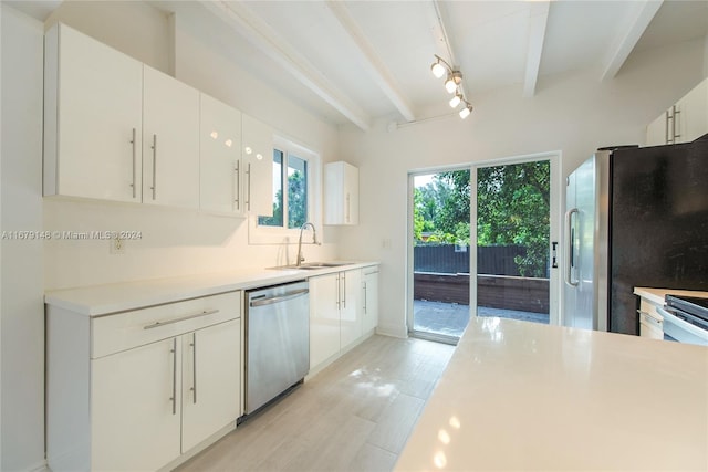 kitchen with white cabinetry, beam ceiling, appliances with stainless steel finishes, and sink