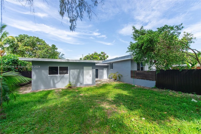 rear view of property featuring a lawn