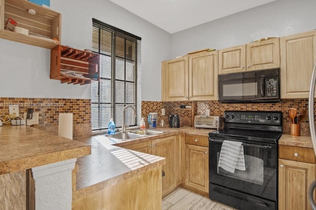 kitchen with a healthy amount of sunlight, black appliances, sink, and kitchen peninsula