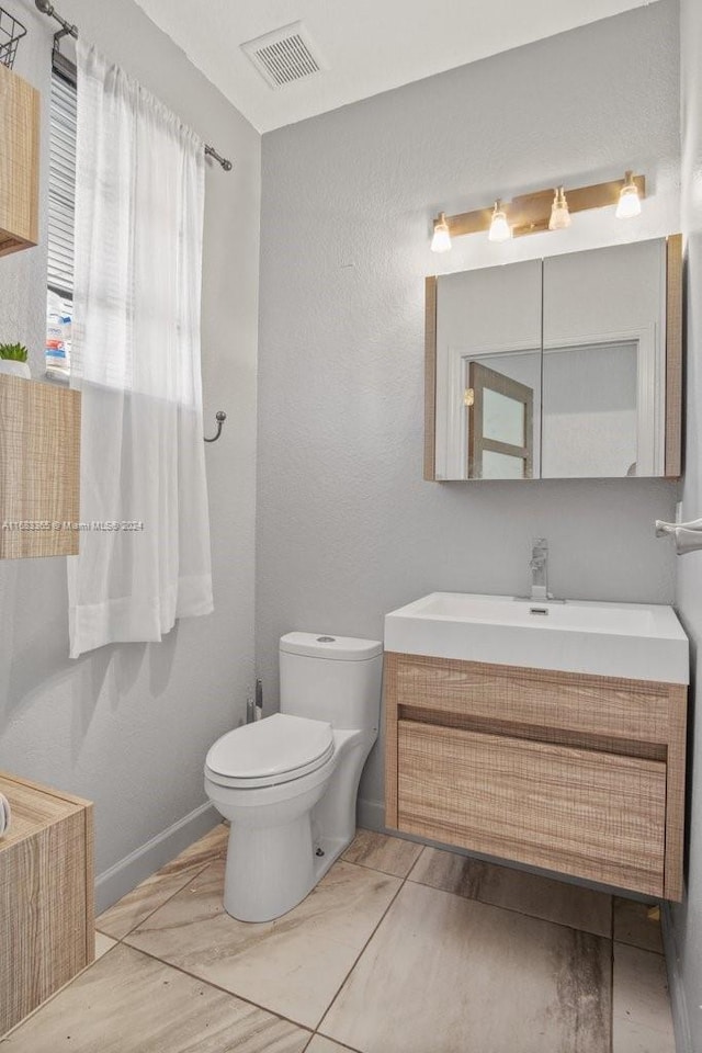 bathroom featuring toilet and vanity