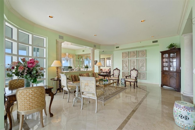 dining space with decorative columns, a wealth of natural light, a chandelier, and ornamental molding