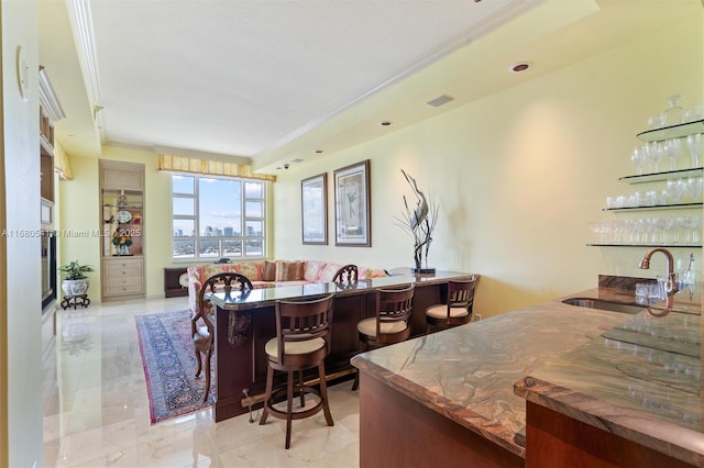 dining room featuring crown molding and indoor wet bar