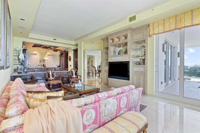 living room featuring ceiling fan, sink, and ornamental molding