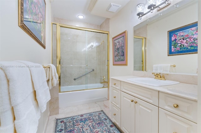 bathroom featuring combined bath / shower with glass door and vanity