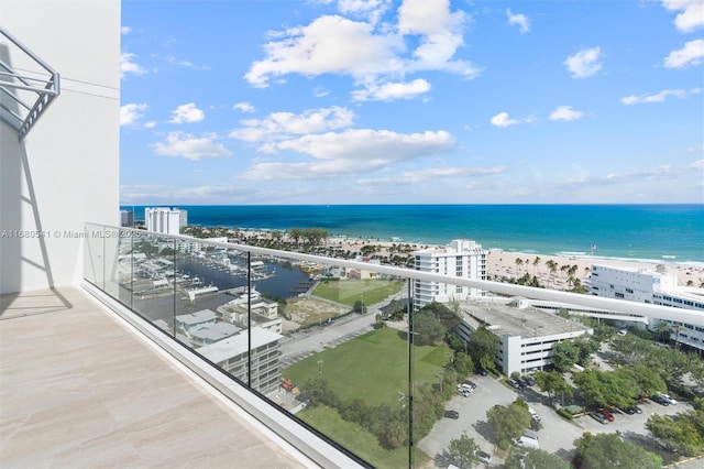 balcony with a water view and a view of the beach