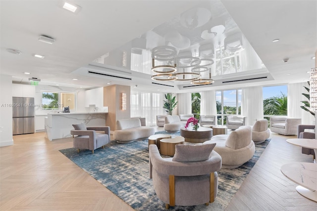 living room featuring a chandelier, a wealth of natural light, and light parquet floors