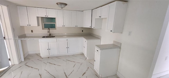 kitchen featuring sink and white cabinets