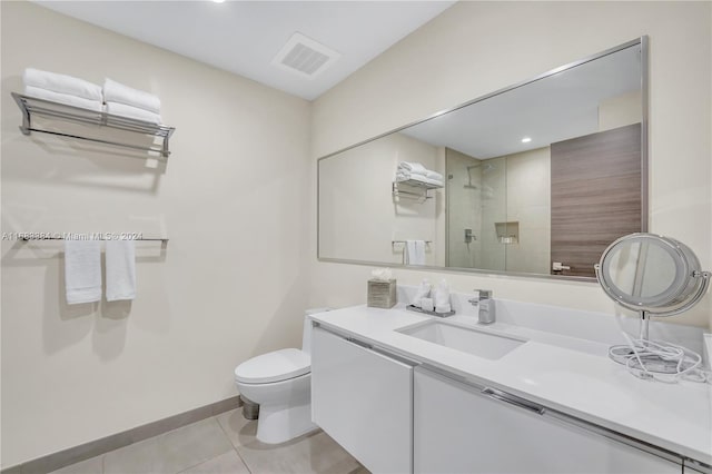 bathroom featuring toilet, tile patterned flooring, vanity, and a shower with door