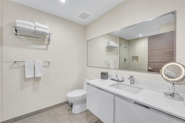 bathroom featuring vanity, a shower with shower door, toilet, and tile patterned floors