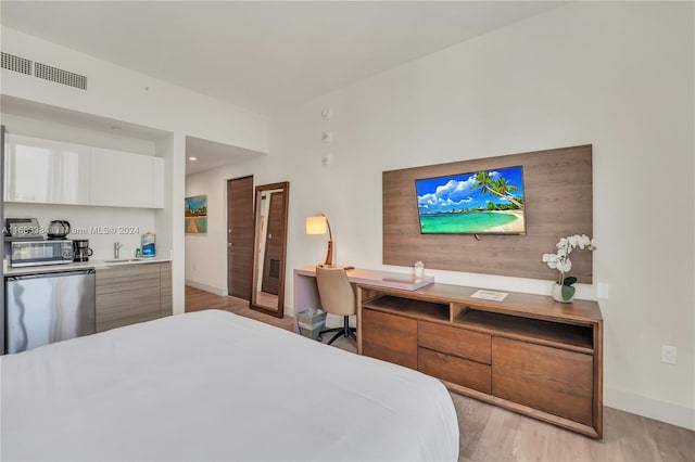 bedroom featuring light hardwood / wood-style floors and sink