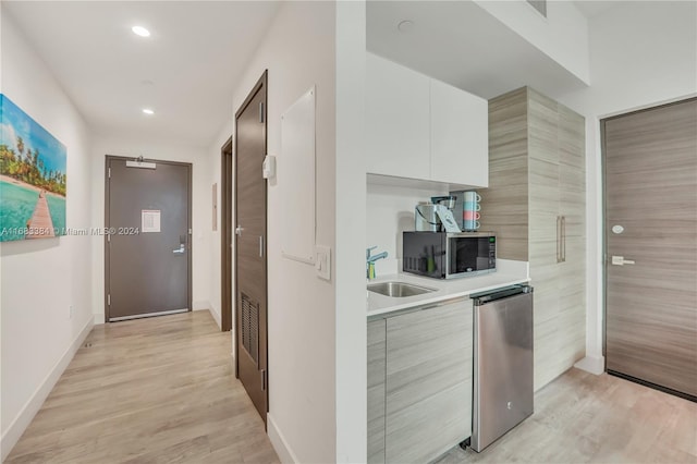 corridor featuring light hardwood / wood-style floors and sink