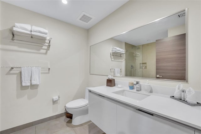 bathroom featuring vanity, toilet, tile patterned floors, and a shower with shower door