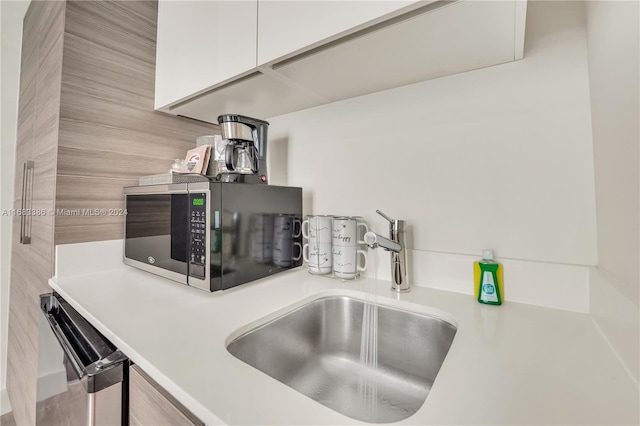 details featuring white cabinets, sink, and stainless steel appliances