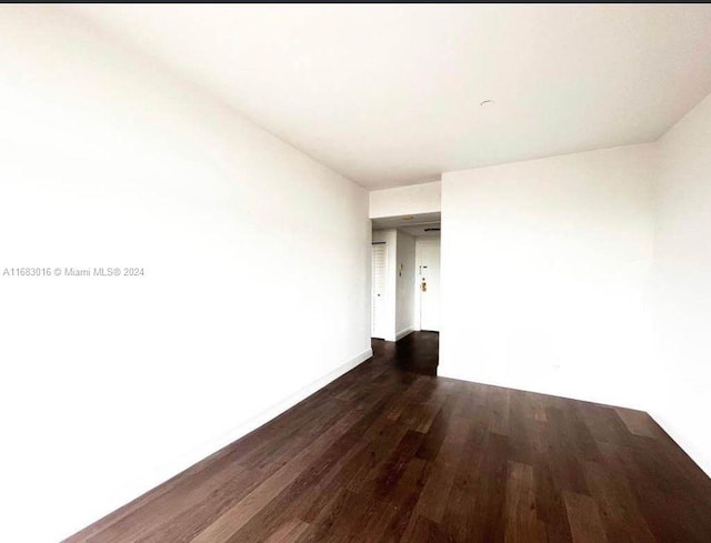 empty room with dark hardwood / wood-style flooring