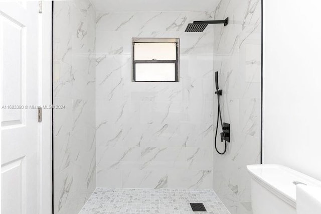 bathroom featuring toilet and tiled shower