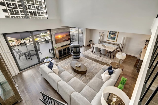 living room with hardwood / wood-style flooring and a towering ceiling