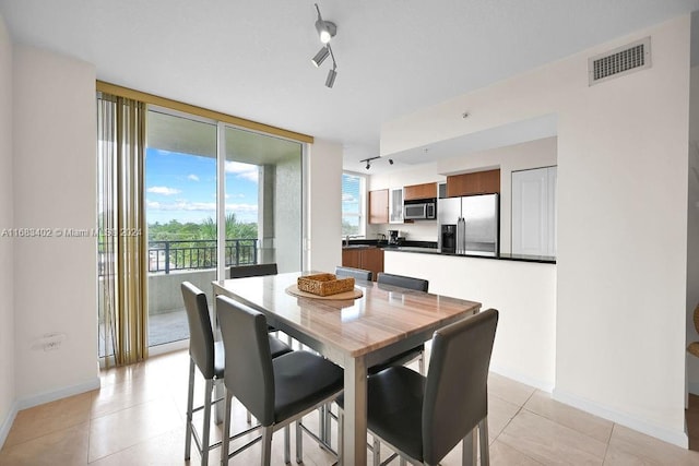 610 W Las Olas Blvd Unit 312N, Fort Lauderdale, FL 33312 - dining space with baseboards, a wall of windows, and light tile patterned floors