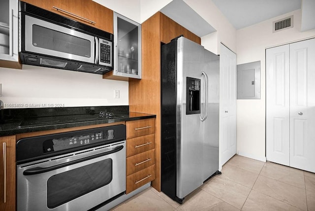 610 W Las Olas Blvd Unit 312N, Fort Lauderdale, FL 33312 - kitchen featuring stainless steel appliances, electric panel, brown cabinetry, dark countertops, and glass insert cabinets