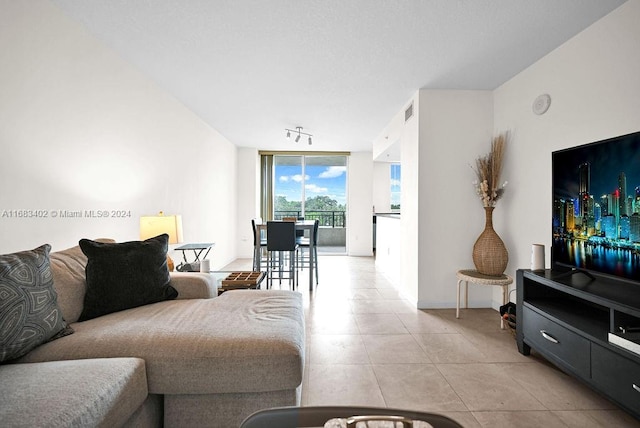 living room featuring a wall of windows and light tile patterned floors