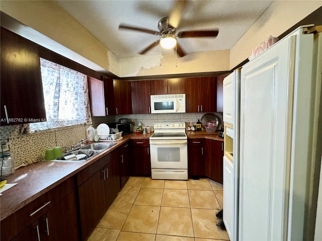 kitchen with backsplash, sink, light tile patterned flooring, white appliances, and ceiling fan