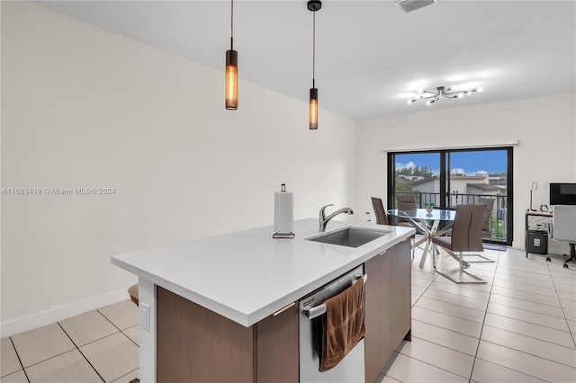 kitchen featuring stainless steel dishwasher, decorative light fixtures, light tile patterned floors, and sink