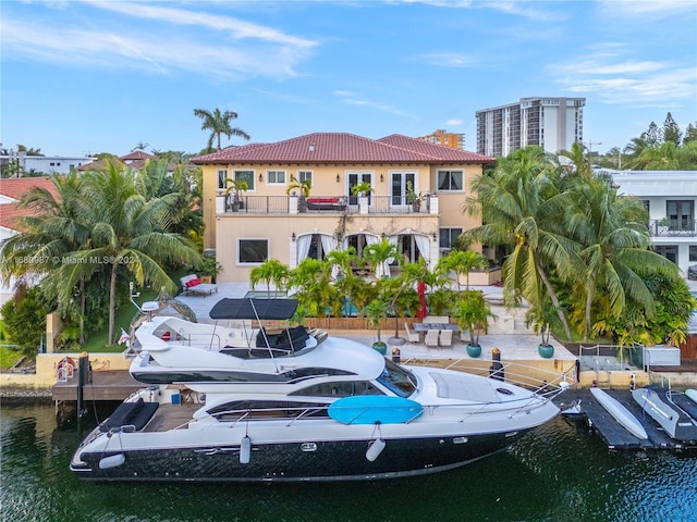 rear view of house featuring a water view and a balcony