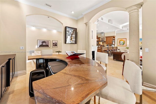 dining area with crown molding, arched walkways, decorative columns, and recessed lighting