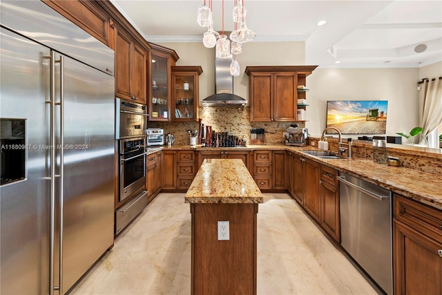 kitchen featuring a center island, wall chimney exhaust hood, a sink, appliances with stainless steel finishes, and a warming drawer