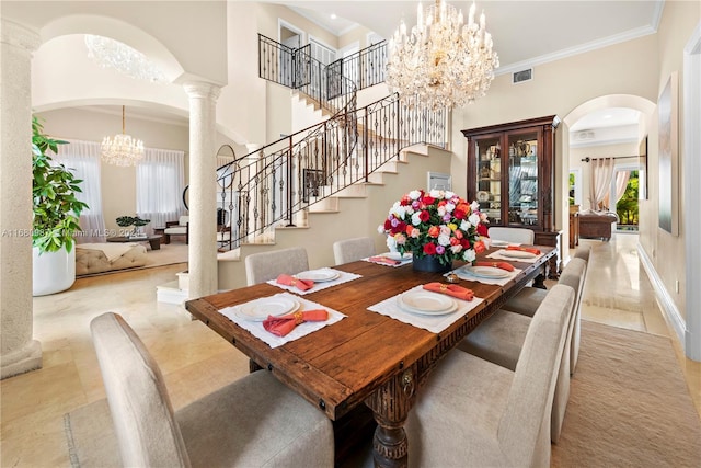 dining area with a high ceiling, ornate columns, crown molding, and an inviting chandelier