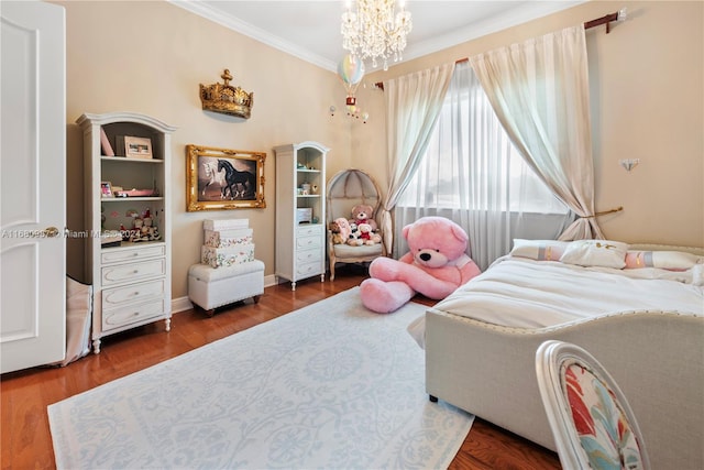 bedroom featuring baseboards, ornamental molding, wood finished floors, and a chandelier