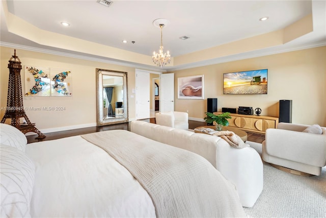 bedroom with ornamental molding, a tray ceiling, and a chandelier