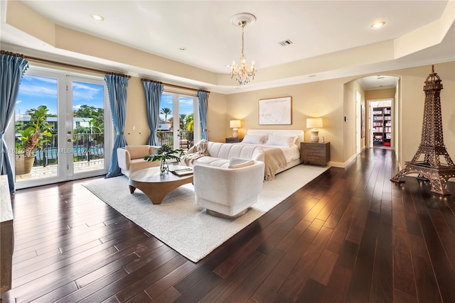 bedroom with french doors, a raised ceiling, access to outside, and dark hardwood / wood-style flooring