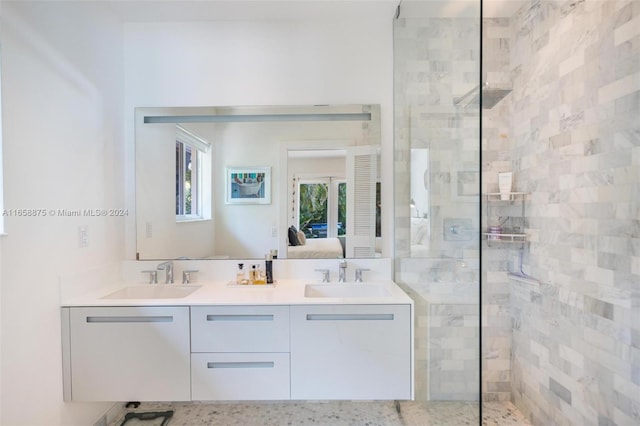 bathroom with a tile shower and vanity