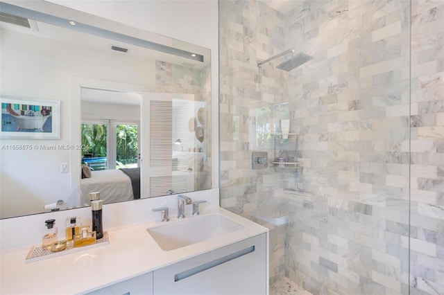 bathroom featuring tiled shower and vanity