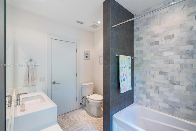 full bathroom with tile patterned flooring, vanity, tiled shower / bath combo, and toilet