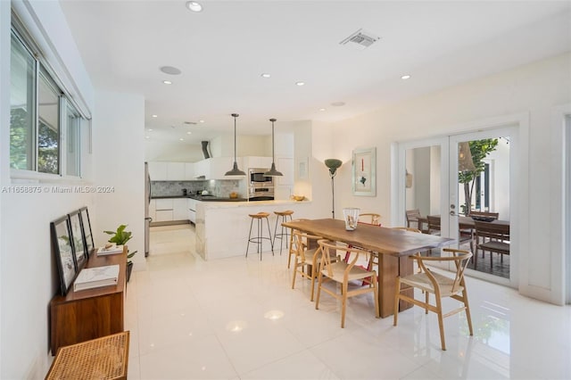 tiled dining space featuring french doors